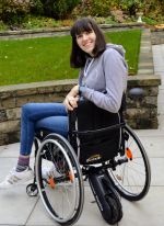 Katie in her wheelchair with the Smartdrive ‘Power wheel add on’ - cropped